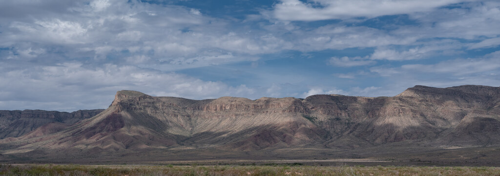 Layered mountain ridge lit through clouds