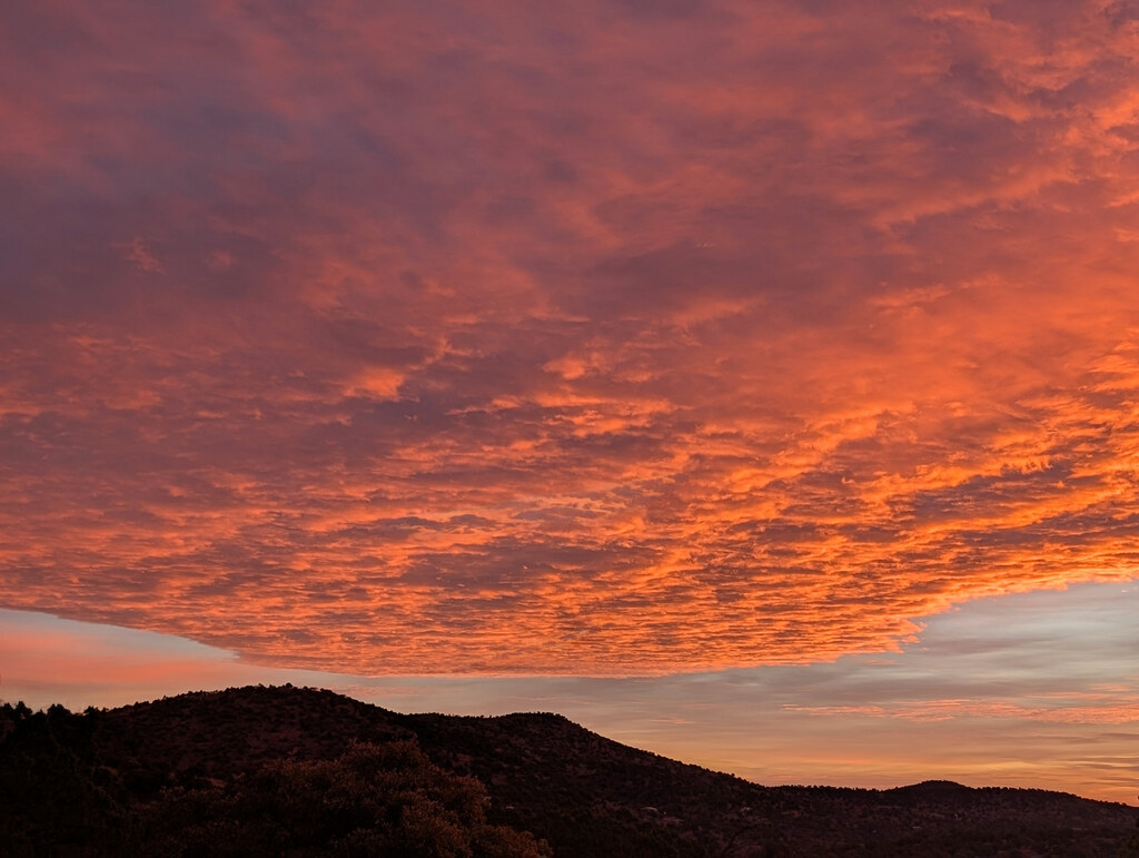 Red sunset clouds above a dark ridge