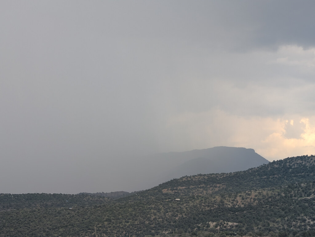 Rain curtain veiling a distant flat-topped mountain