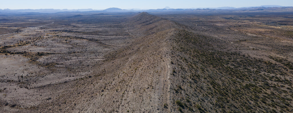 Aerial panorama along a narrow desert ridge