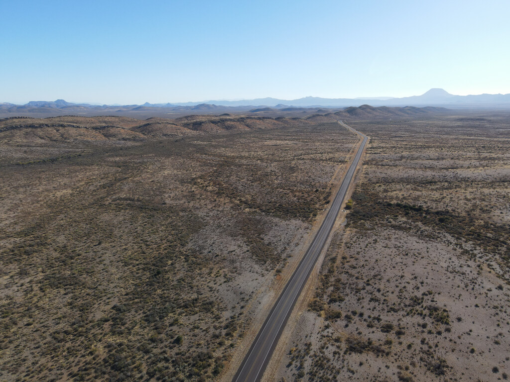 Straight road crossing a broad desert plain