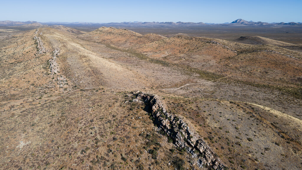 Pale desert ridge broken by a dark rock outcrop
