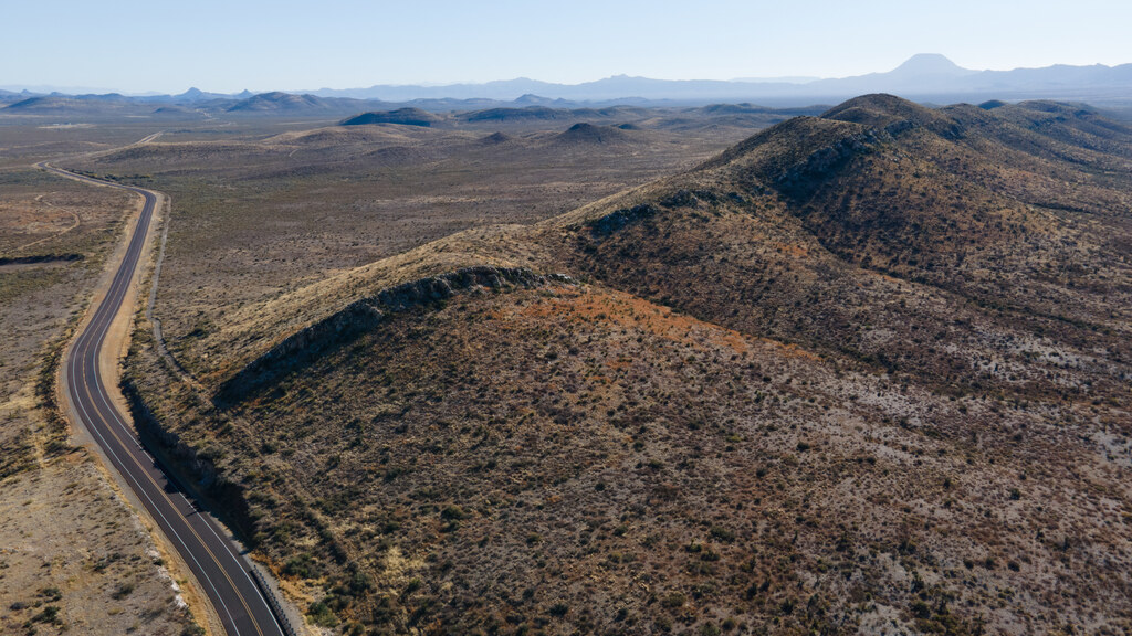Road curving through desert ridges near Marathon