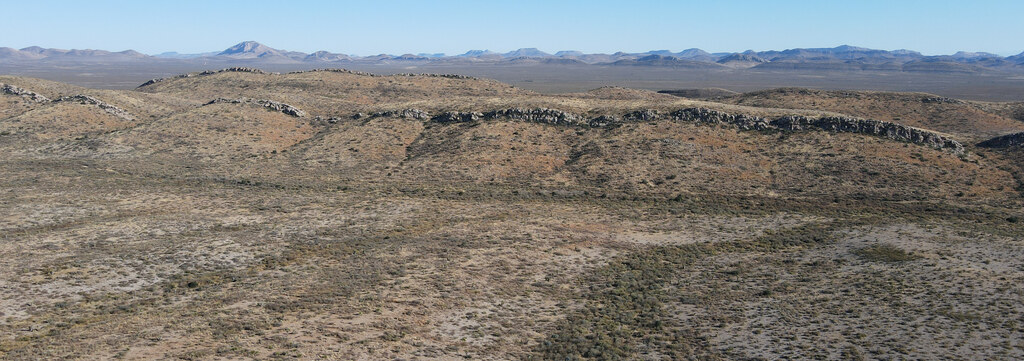 Low dark ridge extending across a desert basin