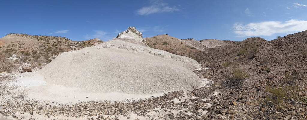 White conical hill beneath a clear blue sky