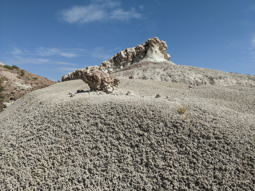 Eroded white ridge rising from a gravel slope