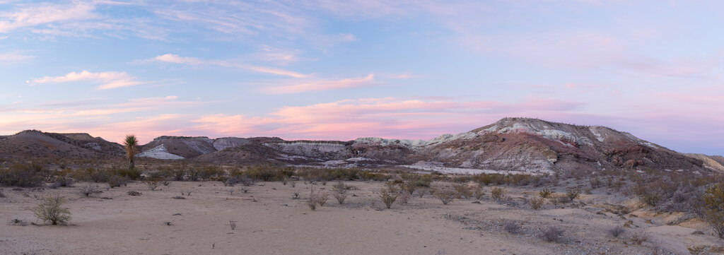 Pale badlands beneath a pink evening sky