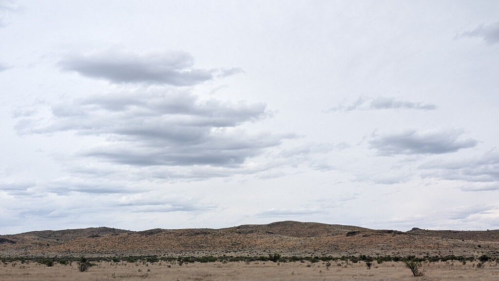 Low stony ridge beneath layered gray clouds