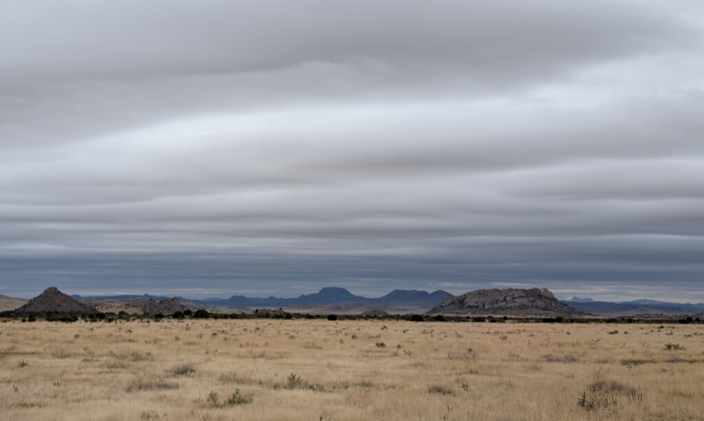 Distant mesas under a low dark cloud deck