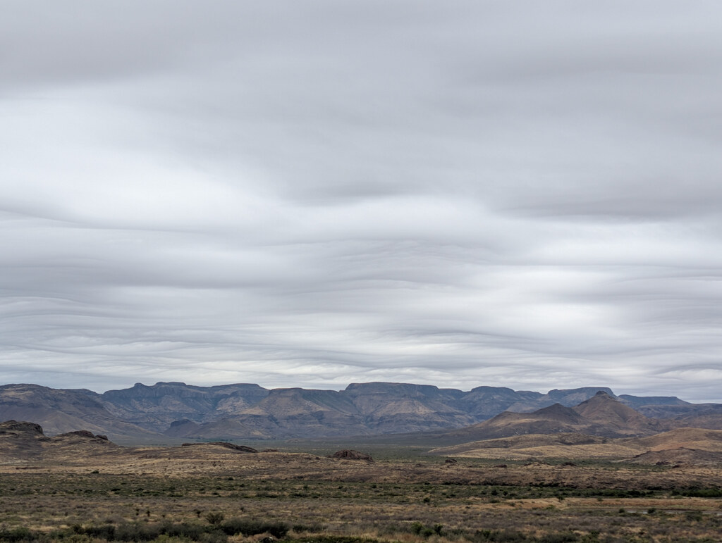Mountain basin beneath streaked gray clouds
