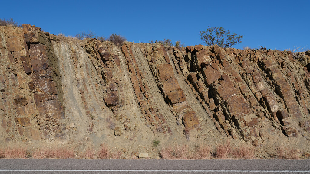 Angular rust-colored rock strata in a roadside cut